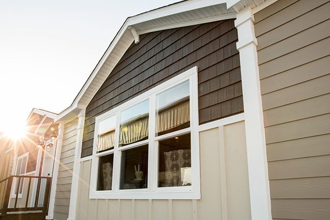 The exterior side of a manufactured home with neighboring residences
