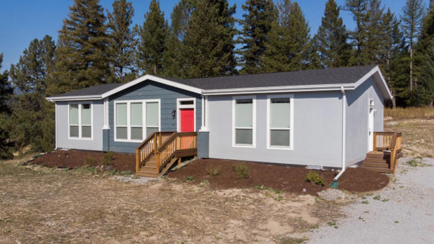 A gray and blue manufactured home often thought of as a mobile home