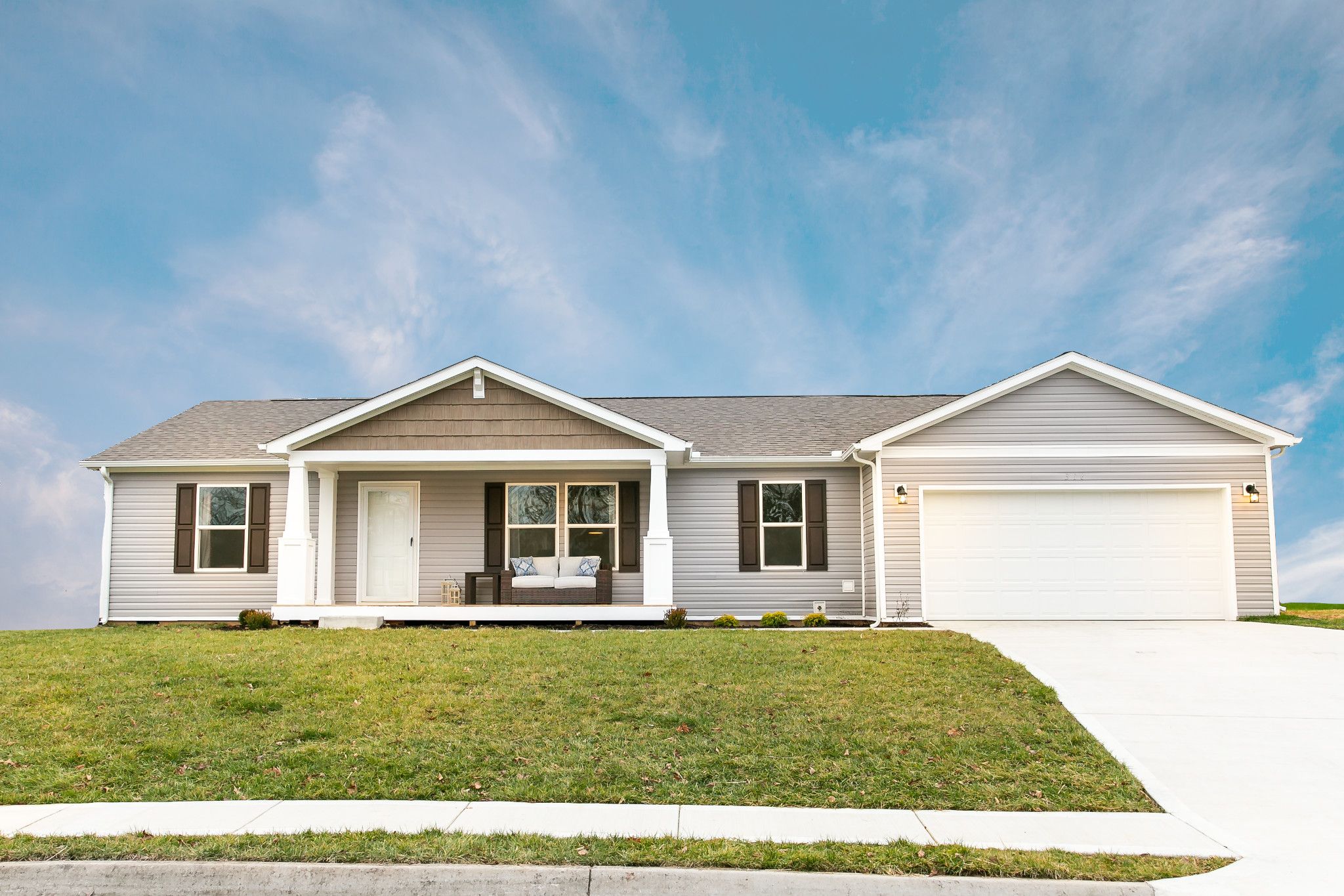 Front view of a double-wide mobile home with a beautiful exterior design and landscaping. 