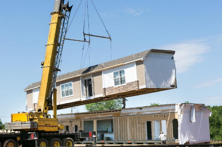 A crane moving a manufactured home