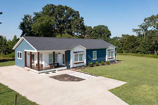 A single-story home with blue vinyl siding and white windows. Without a housing market slowdown, this kind of home would be unaffordable for many Americans with even moderate levels of income.