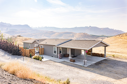 A modular home in a rugged, sun-drenched landscape. Once completed, modular homes can be indistinguishable from traditional site-built homes.