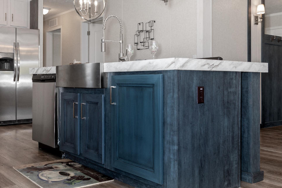 A kitchen island with a farmhouse sink in a remodeled manufactured home