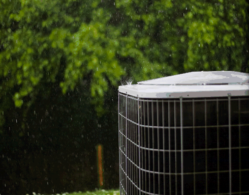 A gentle spring rain falls upon an outside air-conditioning unit