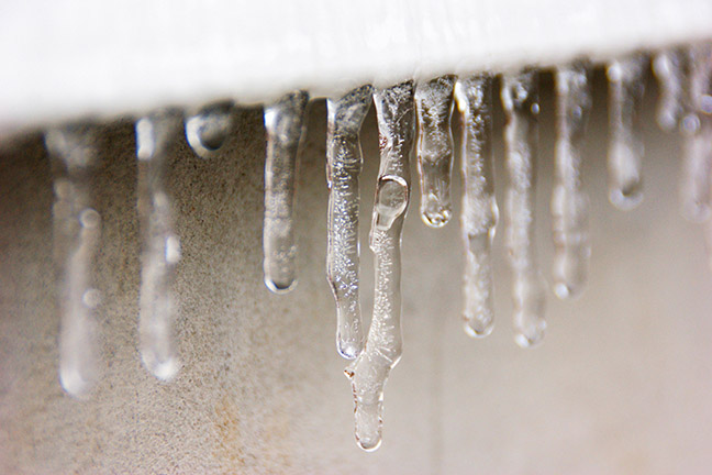 Icicles hanging down from siding on house.