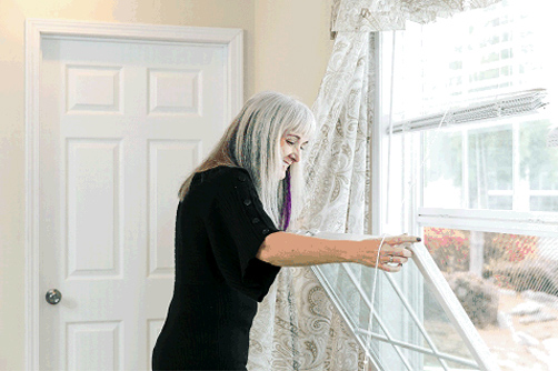 Woman checking her windows as part of her process to winterize home